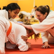 two young female judoka being coached